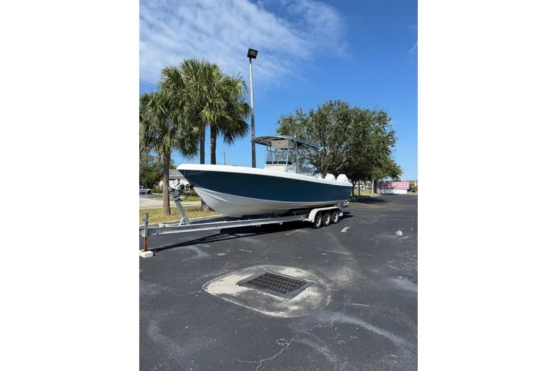 Slide: The Image of 2005 Bluewater 2850 CC boat on trailer, parked under clear blue sky. - 6