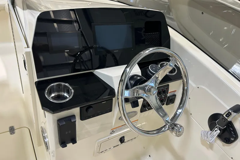 Slide: The Image of 2026 Scout 220 Dorado boat dashboard with steering wheel and electronic displays. - 5
