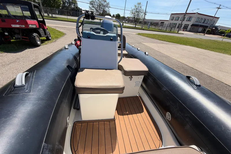 Slide: The Image of 2022 Brig Falcon 420 inflatable boat with seating and steering console, parked outdoors. - 16