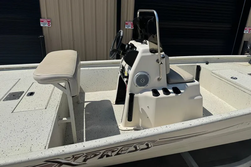 Slide: The Image of 2017 Xpress XP18CC boat interior with console and seating, parked indoors. - 7