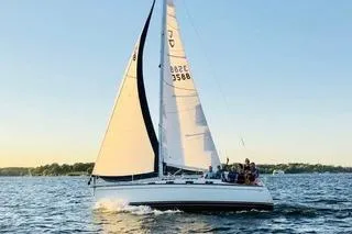 The Image of 1988 Tartan 31 sailboat cruising on a serene lake at sunset. - 1