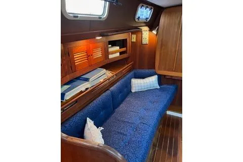 Slide: The Image of Interior of a 1988 Tartan 31 sailboat with blue cushioned seating and wooden accents. - 6