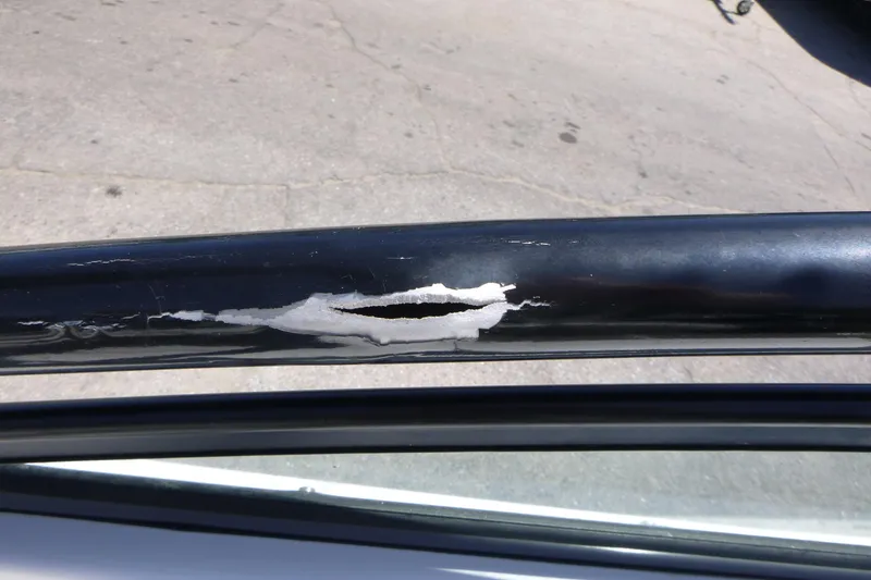 Slide: The Image of Damaged black railing on a 2014 Yamaha Boats AR192, showing peeling paint and surface wear. - 11