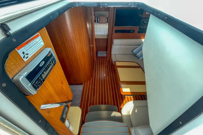Slide: The Image of Interior of 2004 Tiara Yachts 3800 Open, featuring wood paneling and seating area. - 15
