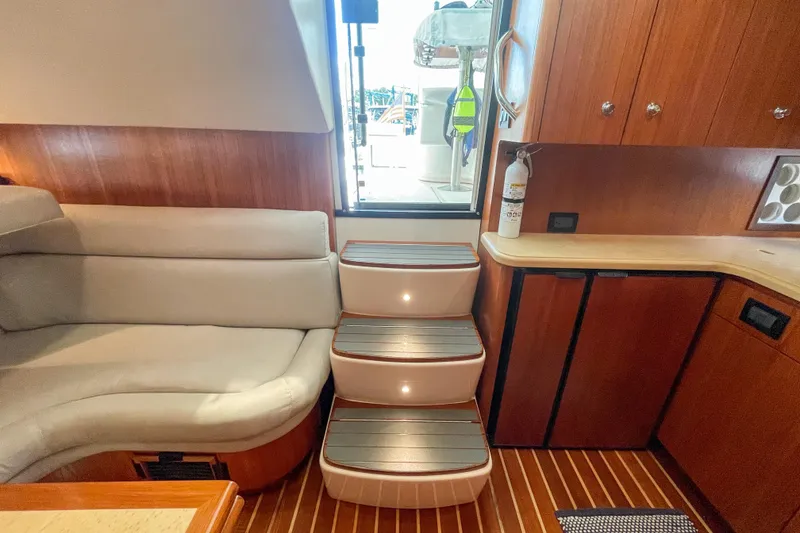 Slide: The Image of Interior of 2004 Tiara Yachts 3800 Open, featuring wooden cabinetry and cushioned seating. - 16