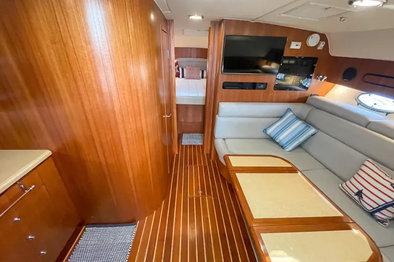 Slide: The Image of Interior of 2004 Tiara Yachts 3800 Open with wood finish, sofa, and TV. - 17