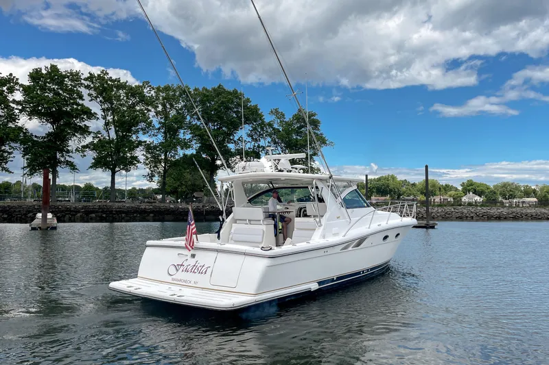 Slide: The Image of 2004 Tiara Yachts 3800 Open cruising on a scenic waterway under a partly cloudy sky. - 2
