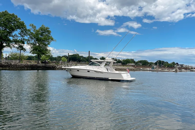 Slide: The Image of 2004 Tiara Yachts 3800 Open cruising on a serene lake under a partly cloudy sky. - 5
