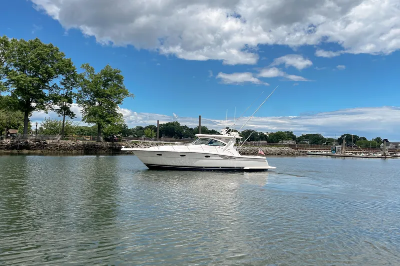 Slide: The Image of 2004 Tiara Yachts 3800 Open cruising on a serene lake under a partly cloudy sky. - 6