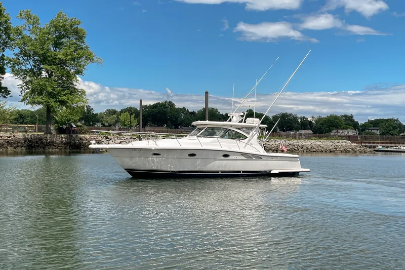 Slide: The Image of 2004 Tiara Yachts 3800 Open cruising on a calm river under a blue sky. - 7