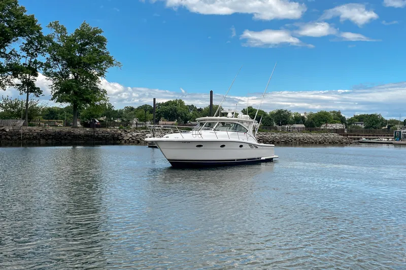 Slide: The Image of 2004 Tiara Yachts 3800 Open cruising on a calm lake under a clear blue sky. - 8