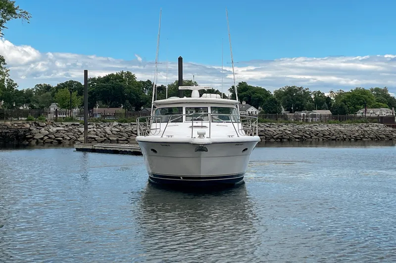Slide: The Image of 2004 Tiara Yachts 3800 Open in a serene marina setting. - 9