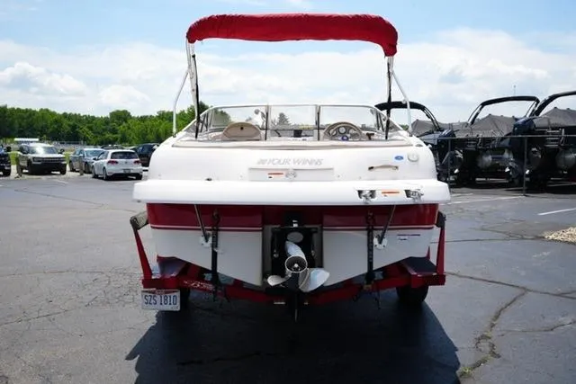 Slide: The Image of 2006 Four Winns 183 Horizon Fish & Ski boat with red canopy in parking lot. - 6