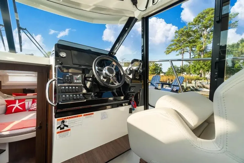 Slide: The Image of Interior view of 2021 Jeanneau NC 1095 boat cockpit with steering wheel and seating. - 12