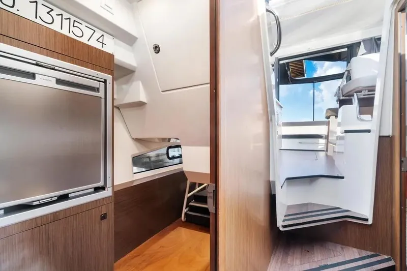 Slide: The Image of Interior view of 2021 Jeanneau NC 1095 boat, featuring modern design and wooden finishes. - 15