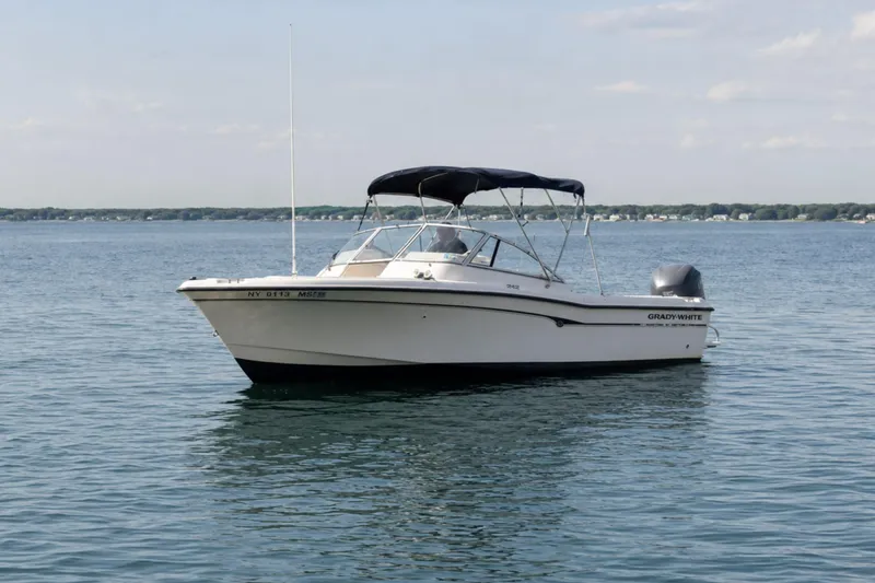 The Image of 2006 Grady-White Freedom 225 boat on calm water with clear sky background. - 0