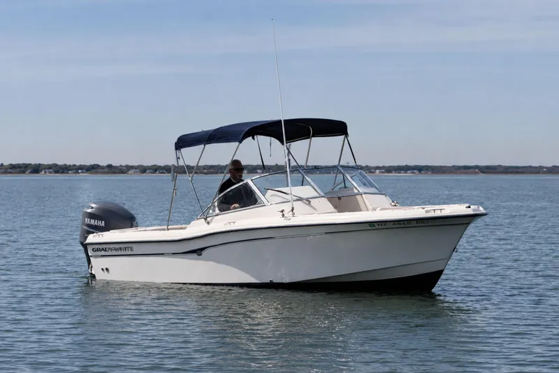Slide: The Image of 2006 Grady-White Freedom 225 boat on calm water with Yamaha engine. - 2