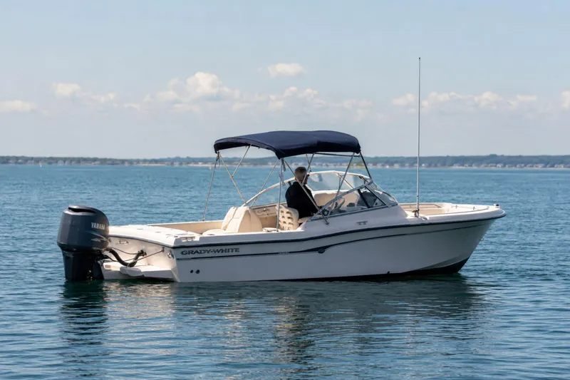 Slide: The Image of 2006 Grady-White Freedom 225 boat on calm water with blue canopy. - 5