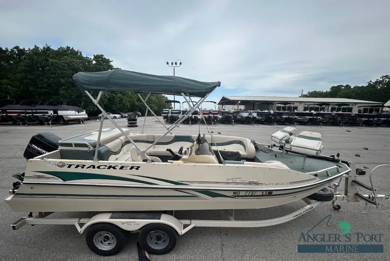 The Image of 2001 Sun Tracker Party Deck boat parked on trailer outdoors. - 1