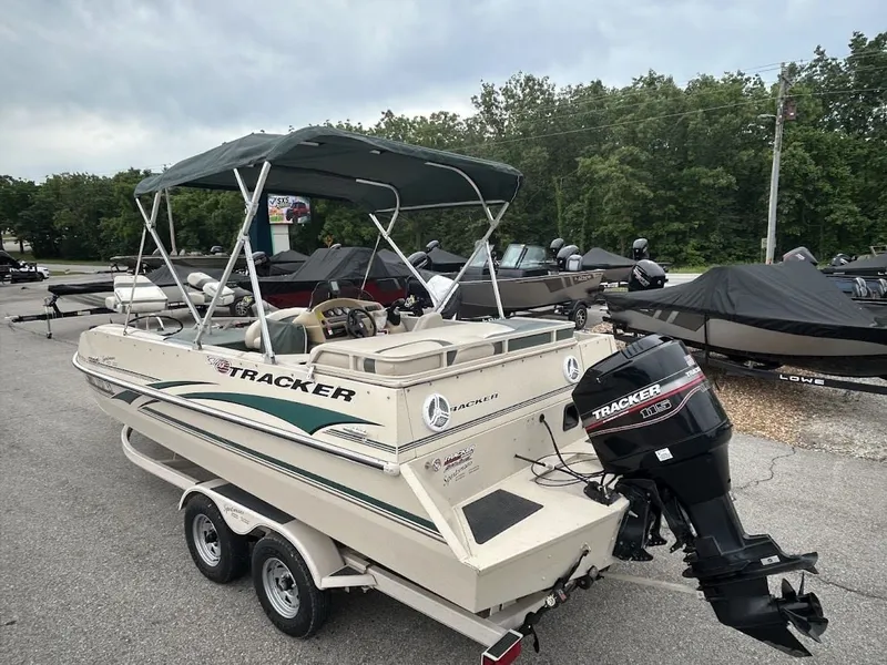 Slide: The Image of 2001 Sun Tracker Party Deck boat with trailer in parking lot. - 4