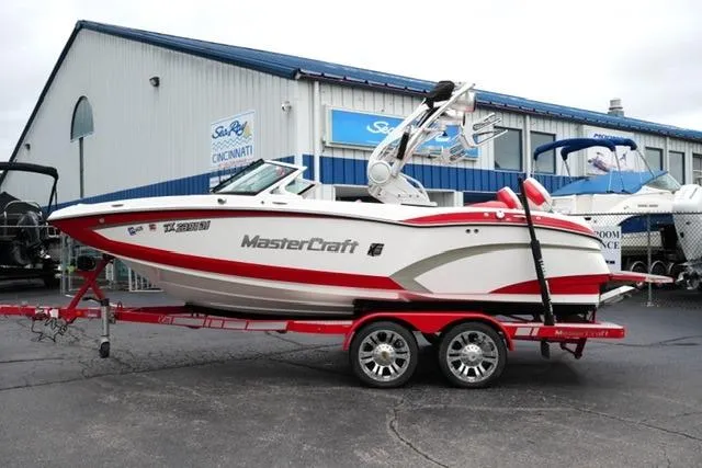 The Image of 2015 MasterCraft X20 boat on trailer, parked outside dealership. - 1