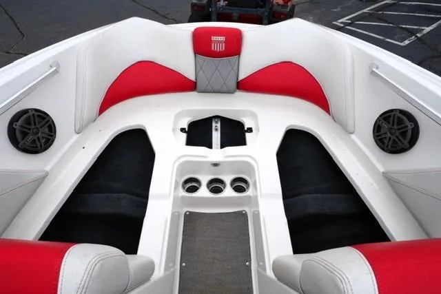 Slide: The Image of 2015 MasterCraft X20 boat interior with red and white seating, cup holders, and speakers. - 10