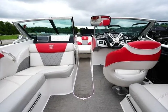 Slide: The Image of 2015 MasterCraft X20 boat interior with red and white seating, steering wheel, and dashboard. - 13