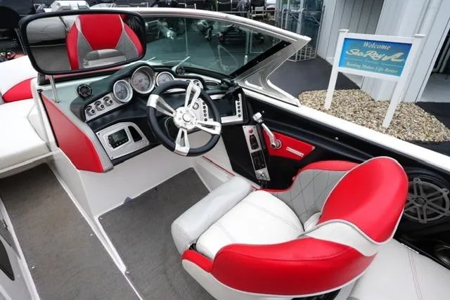 Slide: The Image of 2015 MasterCraft X20 boat interior with red and white seating, modern dashboard, and steering wheel. - 14