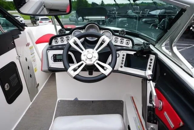 Slide: The Image of 2015 MasterCraft X20 boat dashboard with steering wheel and control panels. - 15