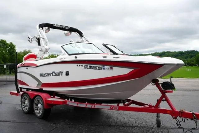 Slide: The Image of 2015 MasterCraft X20 boat on red trailer, parked outdoors. - 3
