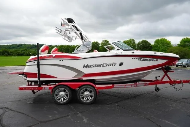 Slide: The Image of 2015 MasterCraft X20 boat on a red trailer, parked outdoors. - 4