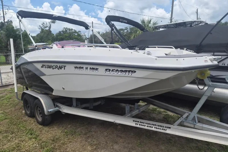The Image of 2022 Starcraft SVX 171 OB boat on trailer, parked outdoors under a cloudy sky. - 1