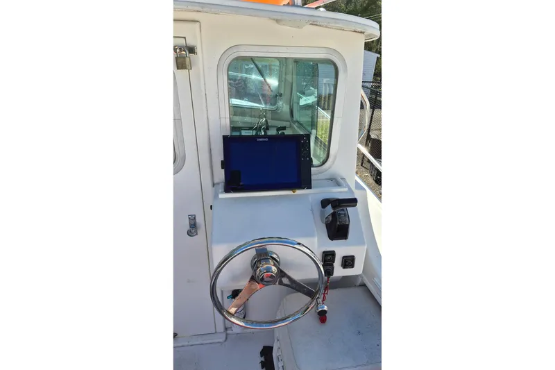 Slide: The Image of Steiger Craft 25 Chesapeake 2016 boat helm with steering wheel and navigation system. - 11
