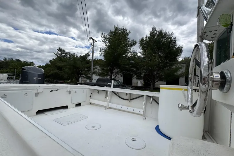 Slide: The Image of 2016 Steiger Craft 25 Chesapeake boat deck with steering wheel, under cloudy sky. - 18