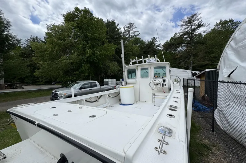 Slide: The Image of 2016 Steiger Craft 25 Chesapeake boat docked outdoors, surrounded by trees and vehicles. - 19