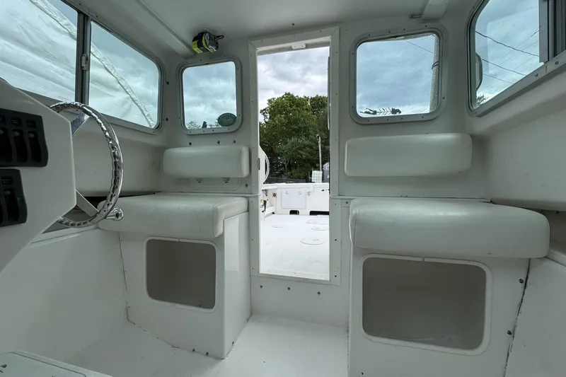 Slide: The Image of Interior of a 2016 Steiger Craft 25 Chesapeake boat, featuring seating and windows. - 22