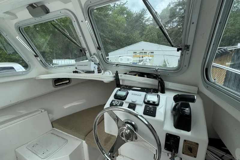 Slide: The Image of 2016 Steiger Craft 25 Chesapeake boat cockpit with steering wheel and navigation controls. - 24