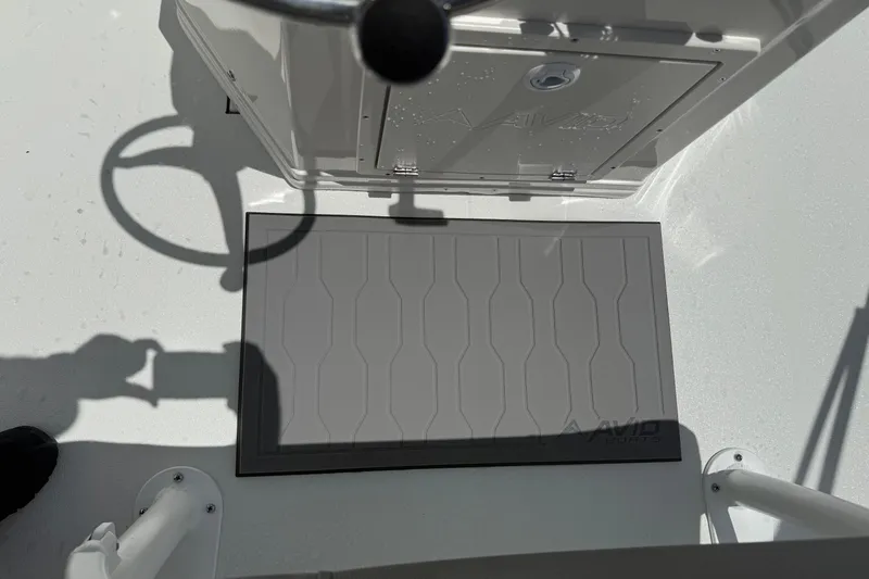 Slide: The Image of Avid 21 Mag 2026 boat deck with steering wheel and storage compartment. - 17
