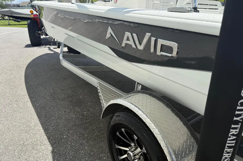 Slide: The Image of Avid 21 Mag 2026 boat on trailer, showcasing sleek design and branding. - 6