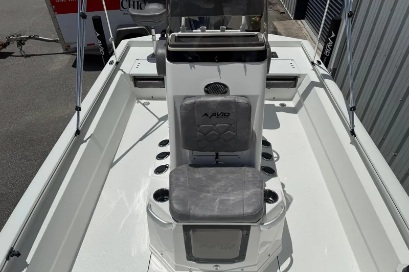 Slide: The Image of Avid 21 Mag 2026 boat interior with seating and console, docked outdoors. - 8
