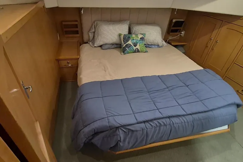Slide: The Image of Cozy bedroom in 2009 Endeavour 40 Skylounge yacht with wooden cabinetry and blue bedding. - 12