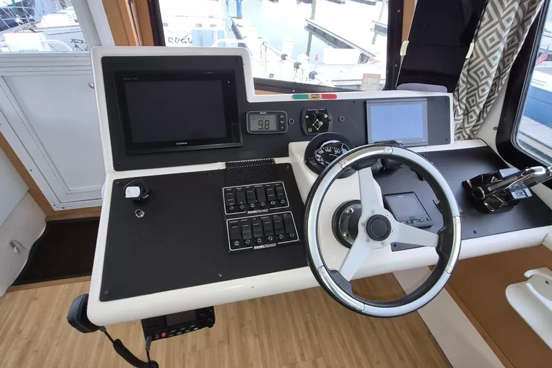 Slide: The Image of Helm of 2009 Endeavour 40 Skylounge with steering wheel, controls, and navigation screens. - 2