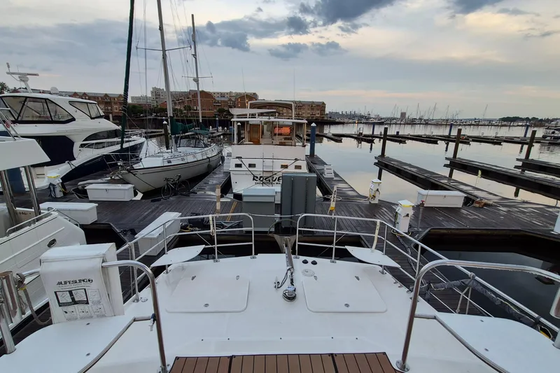 Slide: The Image of 2009 Endeavour 40 Skylounge yacht docked at a marina with surrounding boats and calm waters. - 37