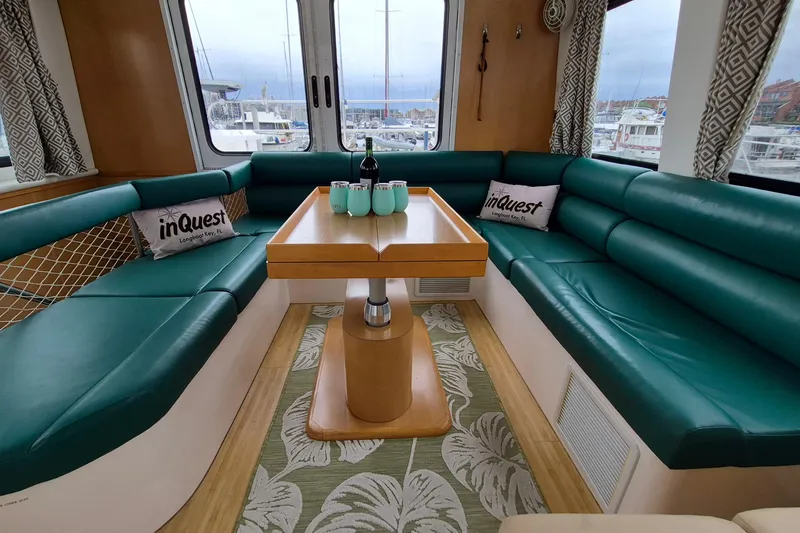 Slide: The Image of Luxurious 2009 Endeavour 40 Skylounge interior with teal seating and elegant dining area. - 5
