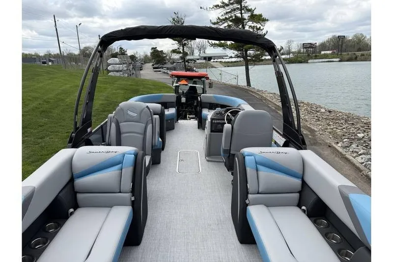 Slide: The Image of 2026 South Bay 224 RS 3.0 Hybrid Arch pontoon boat with spacious seating by a lakeside. - 7