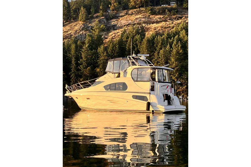 Slide: The Image of 2005 Silverton 39 Motor Yacht on calm water, surrounded by forested hills. - 2