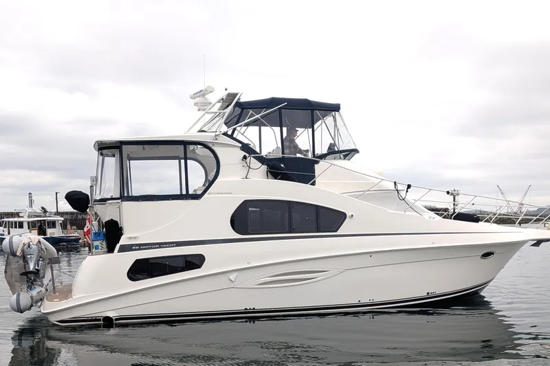 Slide: The Image of 2005 Silverton 39 Motor Yacht docked on calm water under cloudy skies. - 5