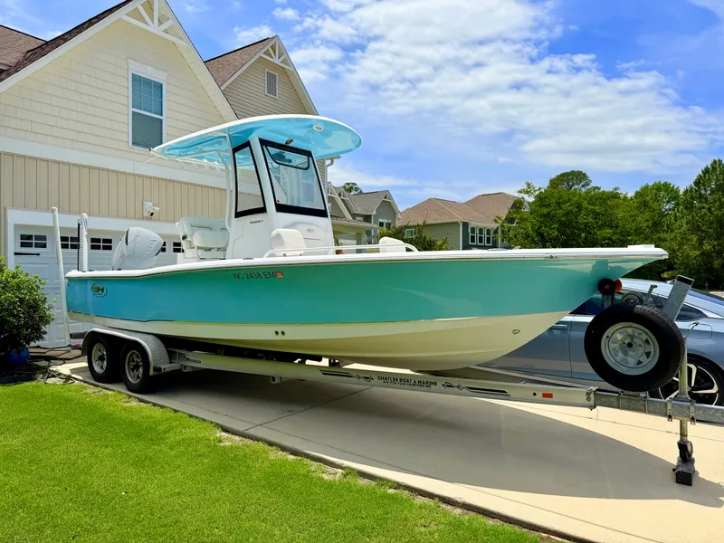 Slide: The Image of 2019 Sea Hunt BX 25 FS boat on trailer in front of house. - 2