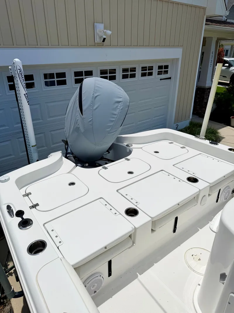 Slide: The Image of 2019 Sea Hunt BX 25 FS boat with engine cover, parked by garage. - 22