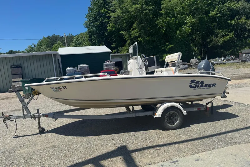 Slide: The Image of 2005 Sea Chaser 175 RG boat on trailer, parked outdoors near storage buildings. - 6